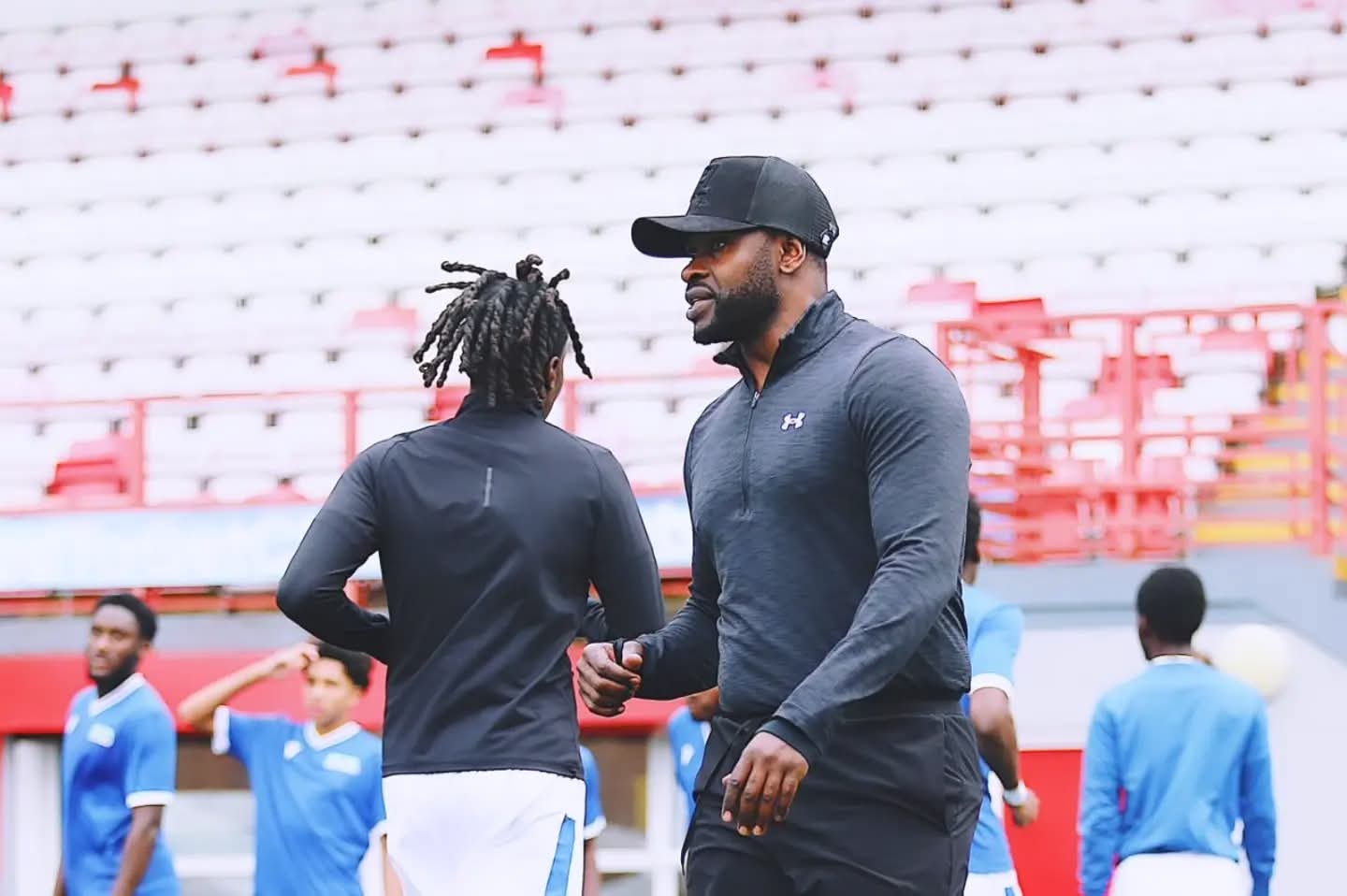 WNC coach guiding an athlete during a pre-match warm-up at the stadium